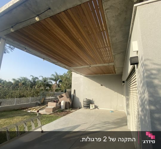 תקרה מעץ עם תאורה תלויה בחצר